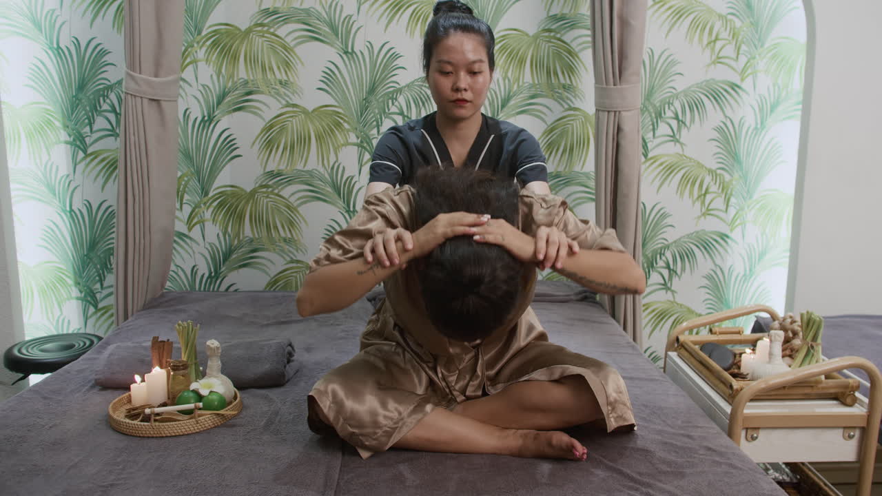 Masseuse Pulling Womans Back during Thai Massage Session