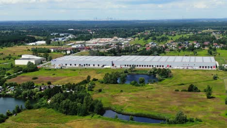 Semi-trailer-trucks-stand-at-the-ramps-of-warehouse-in-the-logistics-park-with-loading-hub-and-wait-for-load-and-unload-goods-at-sunset