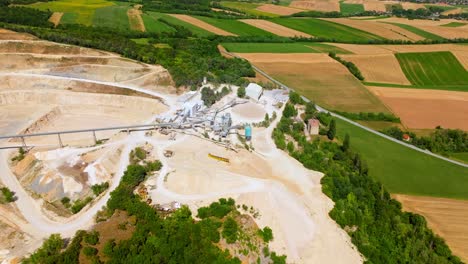 Aerial-View-Of-Limestone-Quarry-Surrounded-With-Agriculture-Fields---drone-shot