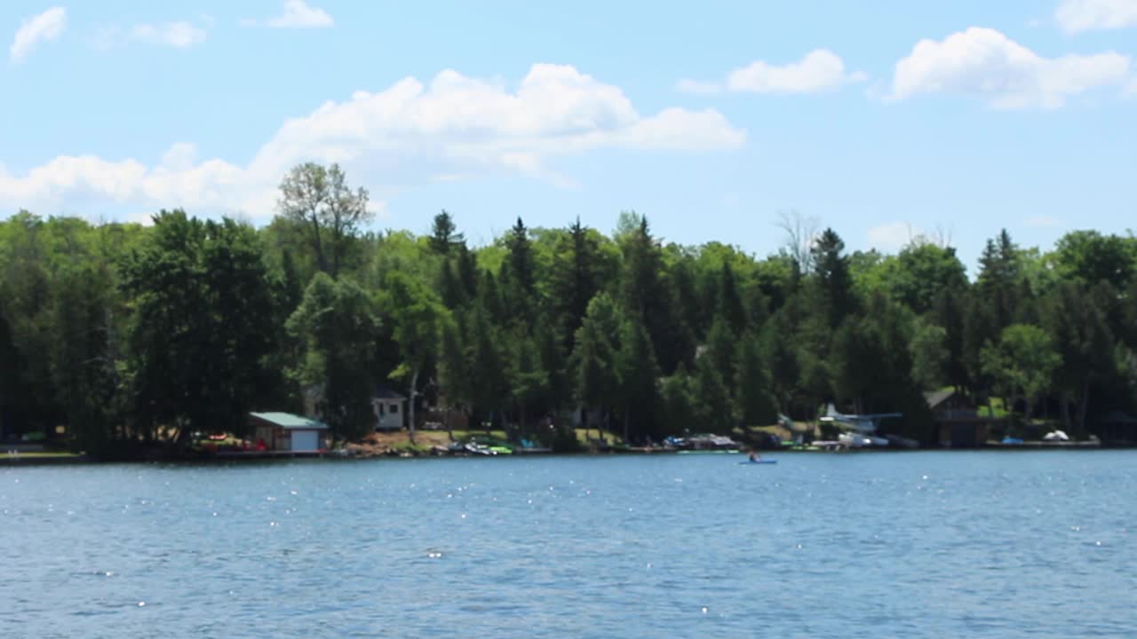 Bright Blue Sky Over The Green Forest By The Kawartha Lakes In Ontario, Canada. View From A Moving Boat