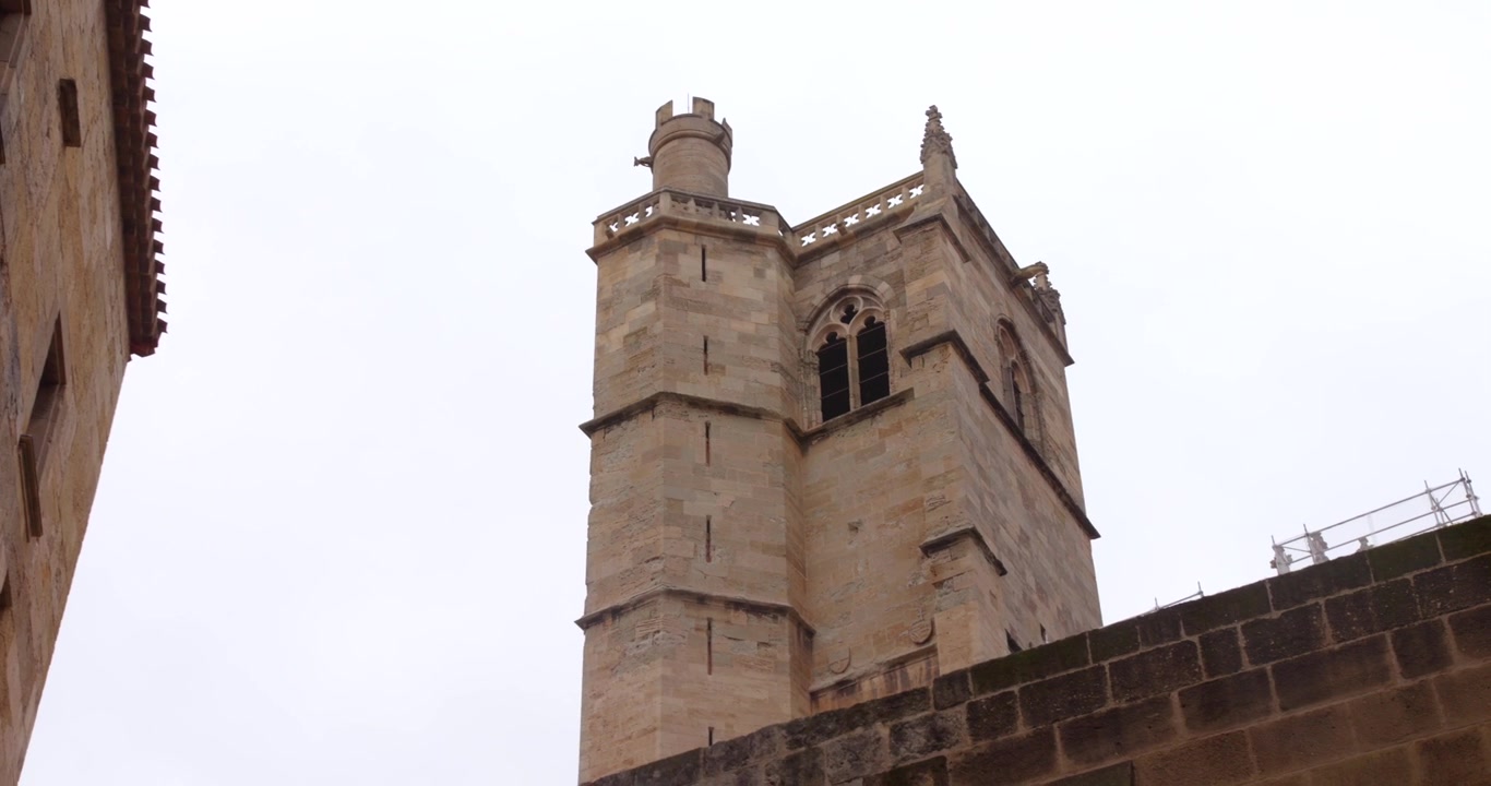 Torre in pietra del Palazzo degli Arcivescovi si erge contro un cielo coperto.