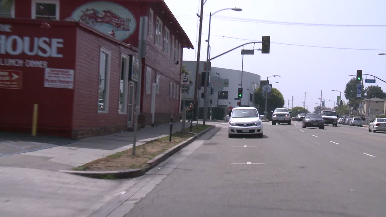 un automóvil viaja a lo largo de una calle en venecia, california, como se ve a través de la ventana trasera 1