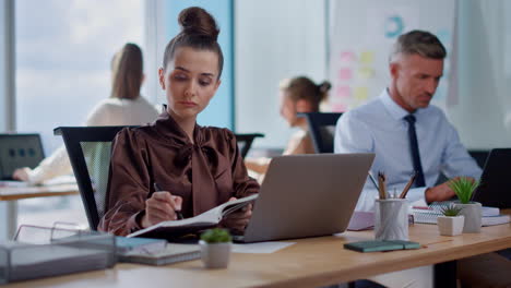 businesswoman making notes in business diary. business woman working on laptop