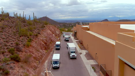 Drone-shot-of-trucks-pulling-in-behind-a-hotel-or-large-building