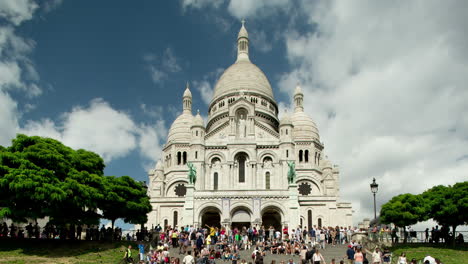 sacre coeur cathedral in paris with tourists on the steps