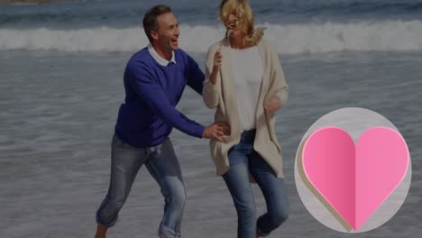 Animation-of-heart-icon-over-caucasian-couple-in-love-running-on-beach