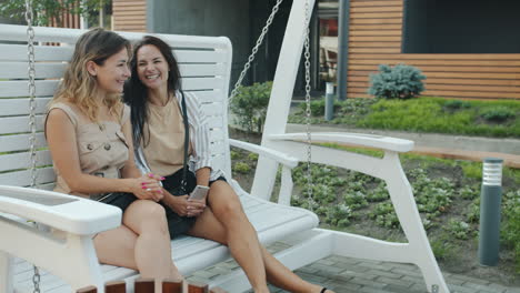 two women relaxing on a swing