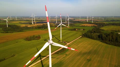 Imágenes-Aéreas-De-Turbinas-Eólicas-En-Un-Parque-Eólico-Que-Genera-Energía-Eléctrica-Verde-En-Un-Amplio-Campo-Verde-En-Un-Día-Soleado,-En-Taurage,-Lituania