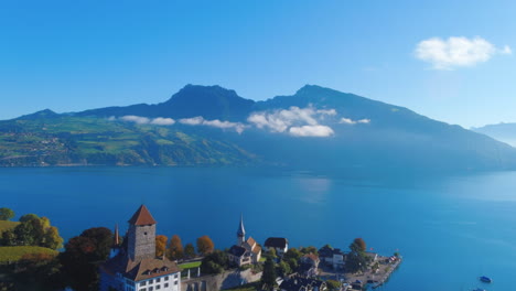 zufriedenstellende drohne überführung des malerischen sees in der nähe der mittelalterlichen kirche in spiez, schweiz im sommer, mittag, weiter blick, europa