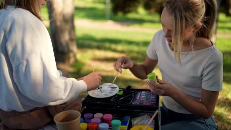teenage girls painting outdoors
