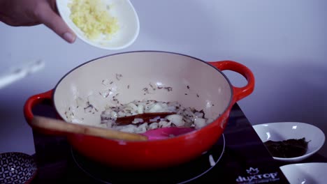 adding-fresh-minced-garlic-to-a-cast-iron-pot-of-ingredients-cooking-fresh-green-papaya-curry