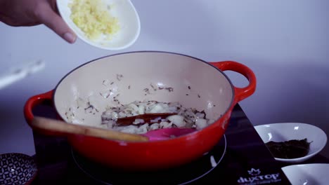 añadir ajo picado fresco a una olla de hierro fundido de ingredientes para cocinar curry de papaya verde fresco