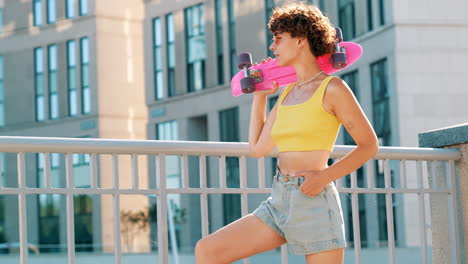 young woman with pink skateboard in the city