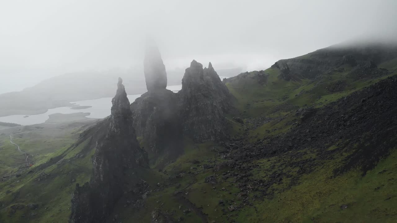 drone disparó hacia atrás el movimiento del anciano del paisaje de storr en la isla de skye escocia, día nublado y hierba verde