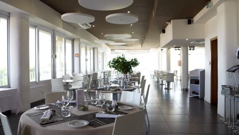 slow revealing shot of a restaurant set ready for dinner service within a spa resort