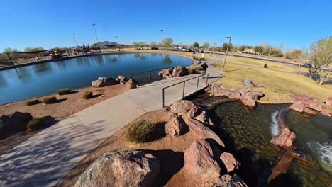 static red haired male walking by a fountain in mansel crater park in queen creek arizona.