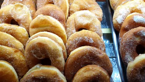 panes en forma de rosquilla con relleno de crema que se exhiben en una vitrina de una panadería brasileña.