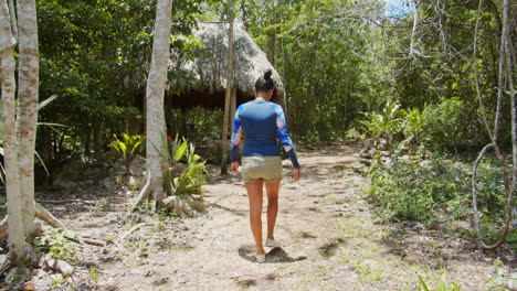 slow motion of mexican girl waking through the muyil archeological site in chunyaxche, quintana roo, mexico