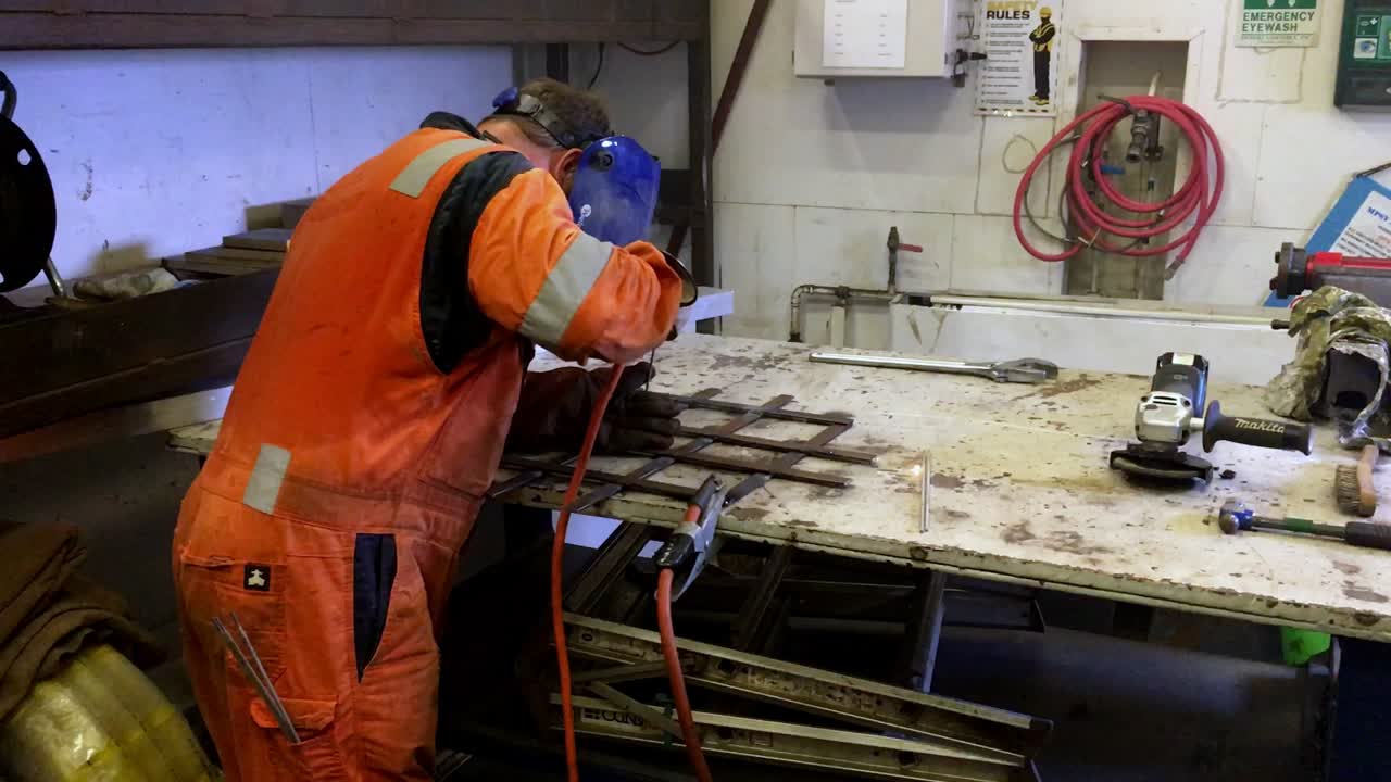 disparo manual detrás de un soldador soldando barras de metal