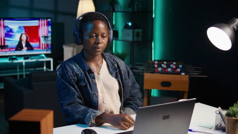 woman working from home at night, looking at laptop