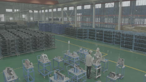 industrial professional technical mechanic wearing uniform walking around car industry warehouse checking stock of used auto parts in factory plant