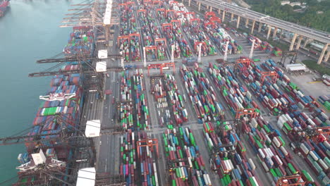 high angle drone panning shot of a busy day at the container terminal in hong kong