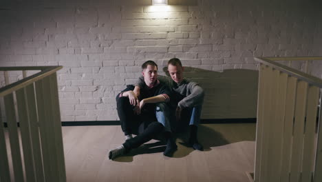 two men sitting together in a room