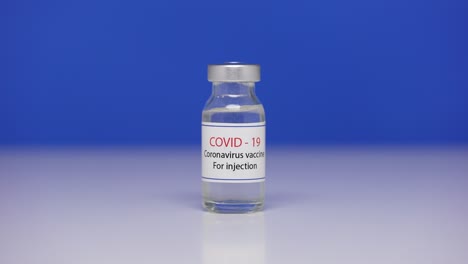 cerrar el vial con la vacuna contra el coronavirus covid-19. botella de vacuna against sars-cov-2 virus en la mesa de laboratorio de fondo. medicamentos contra la pandemia de ncov. pantalla azul, llave de croma. cerrar. lento