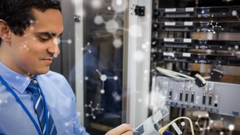 Animation-of-shapes-moving-over-biracial-male-worker-inspecting-server-room