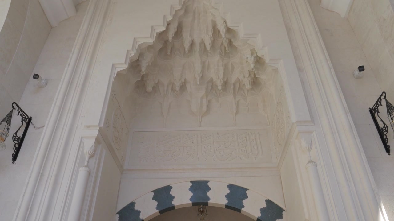 Ingresso della Moschea Namazgah a Tirana, Albania, con volta a muqarnas intagliata e calligrafia in pietra.