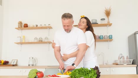 young loving man and woman laughing while cooking healthy food at home young loving man and woman laughing while cooking healthy food at home happy couple love cooking together in kitchen