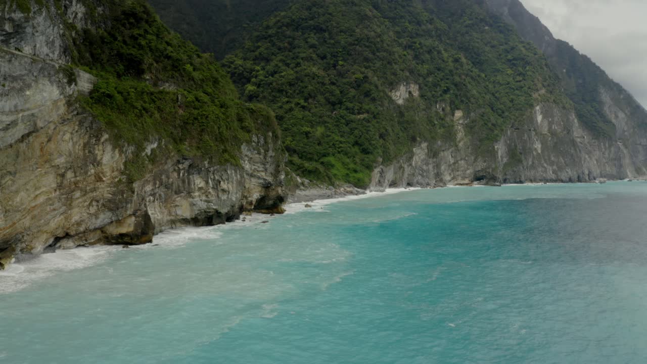 vista aérea baja de los acantilados de qingshui a través de la costa del paisaje marino de la marea azul de la costa del condado de hualien del desfiladero de taroko