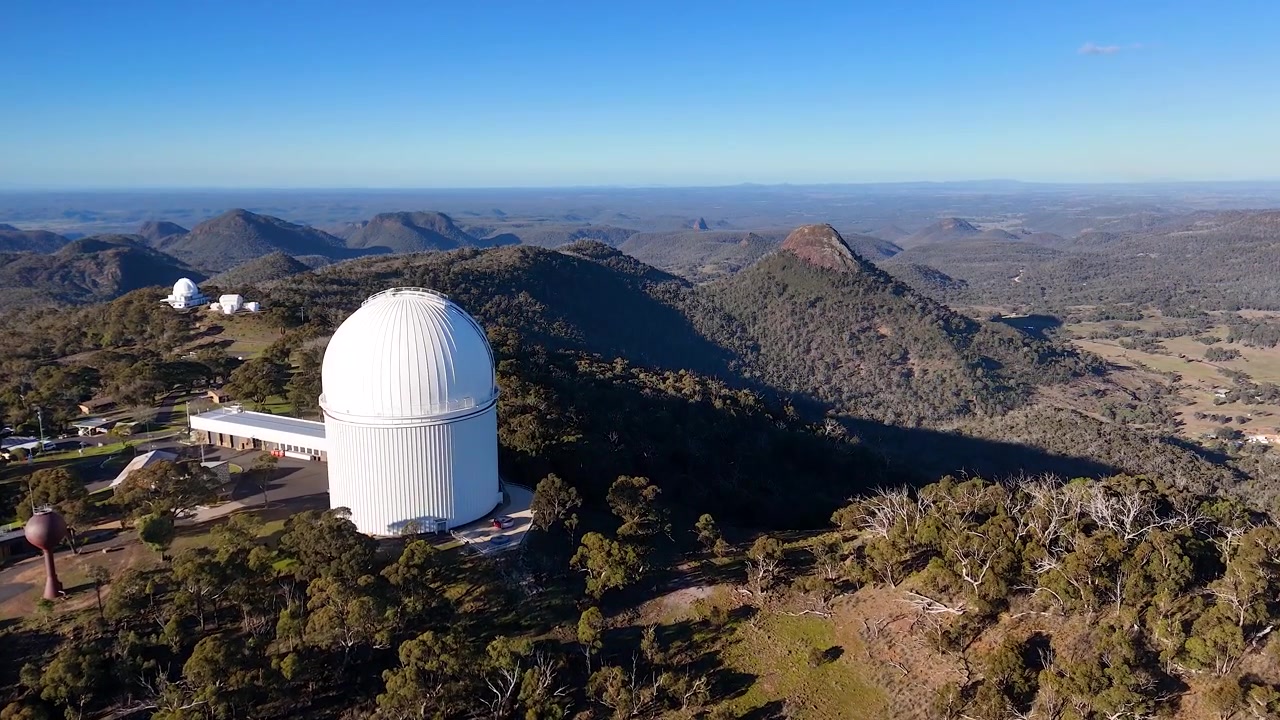 Vidt luftfoto av den hvite teleskopkuppelen ved Siding Spring-observatoriet, Australia