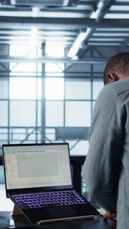 vertical video data center engineer coding on notebook, adjusting power settings