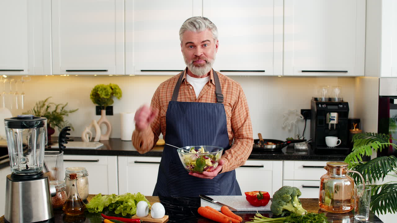 Mann mittleren Alters präsentiert Gemüsesalat-Schüssel in der heimischen Küche für einen gesunden Ernährungs-Meal-Prep-Guide Pro