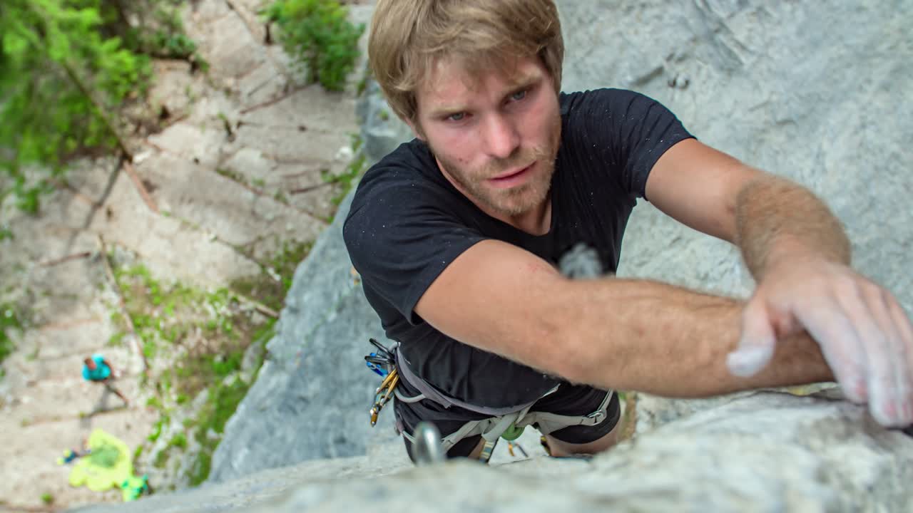 Caucasian man high up on side of mountain rock climbing, Burjakove peci, Topla, Slovenia