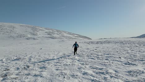 running in mountains with snow and sunshine into the distance
