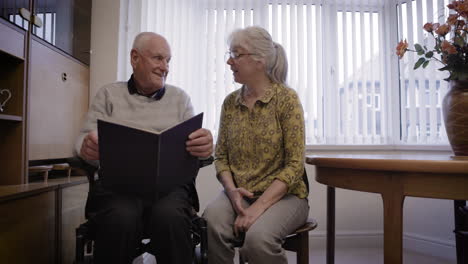 elderly couple reminiscing with photo album