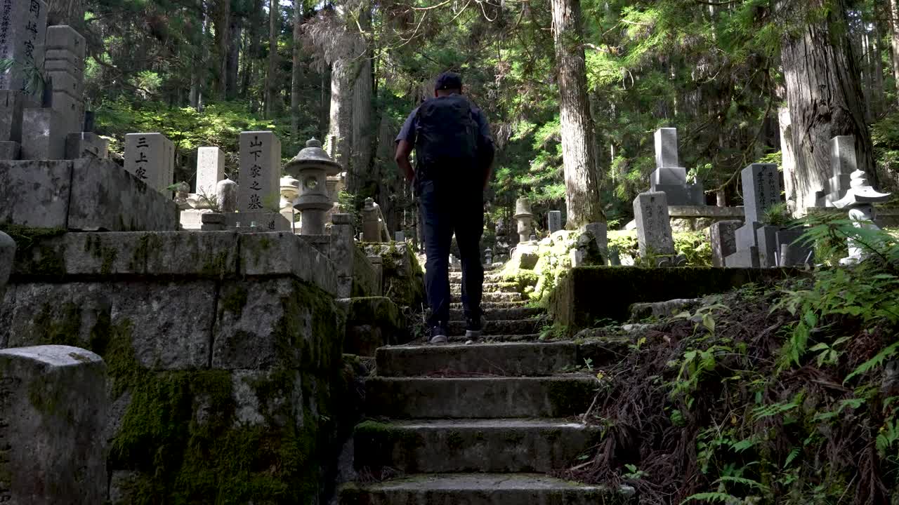 hombre solitario subiendo las escaleras en el tranquilo cementerio del bosque sereno