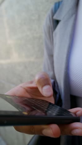 mujer usando un teléfono inteligente al aire libre