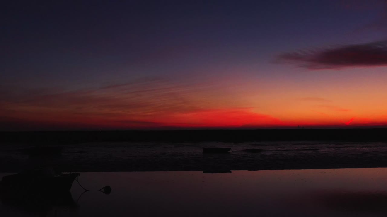Matala, tumma pyyhkäisypanorointi vasemmalta oikealle paljastaa kaksi venettä punaisessa auringonnousussa, DJI Mavic 2 Pro 4K