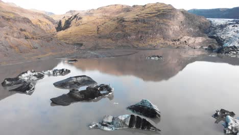 lago fangoso y hielo sucio de la morrena del glaciar sólheimajökull en islandia