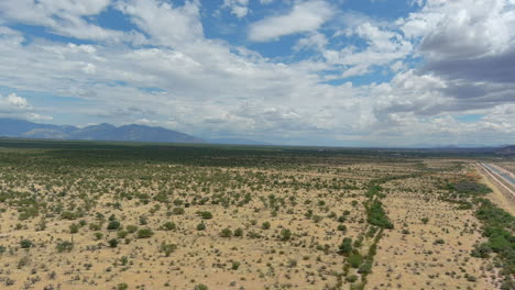 Drone-shot-of-the-Sonoran-desert-in-Arizona,-slow-moving-aerial-shot-with-a-highway-on-the-edge