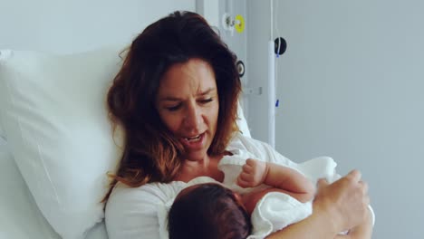 Front-view-of-Caucasian-mother-holding-her-newborn-baby-in-the-ward-at-hospital