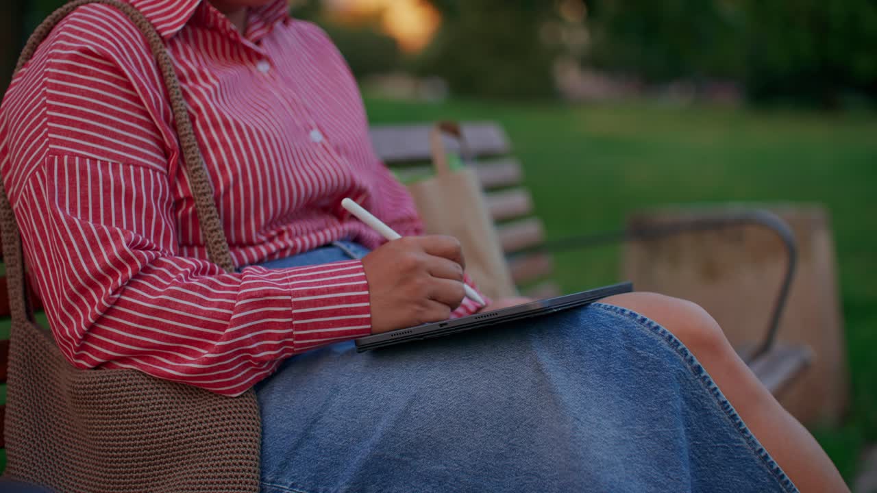Woman Drawing on Tablet in Park
