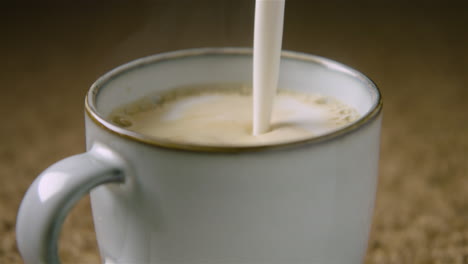 60fps, delicious frothy oat milk is poured into a cup to make a cappuccino