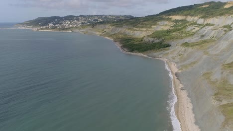 backtracking aerial of charmouth beach looking west along to lyme regis