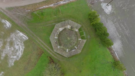 beautiful aerial establishing view of old wooden windmill in the middle of the field, prenclavu windmill , overcast winter day, descending birdseye drone shot