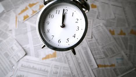 alarm clock falling over sheets of paper