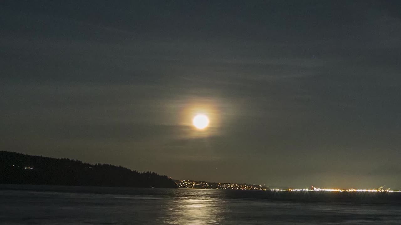 Reflexo da lua cheia nas águas cintilantes de Puget Sound surgindo acima de Tacoma, Washington, time-lapse em movimento, hyperlapse
